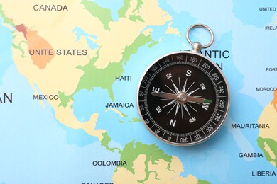 Photo of One compass on world map, top view. Space for text