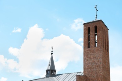 Photo of Exterior of beautiful brick church with tower against blue sky