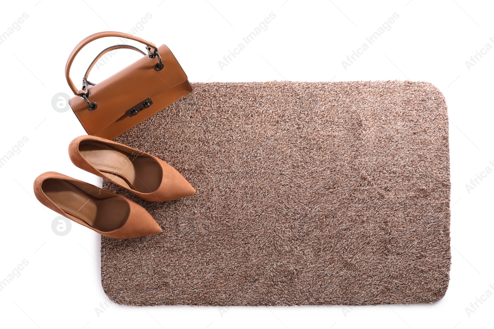 Photo of Stylish door mat with high heeled shoes and bag on white background, top view