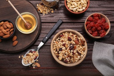 Tasty granola served with nuts and dry fruits on wooden table, flat lay