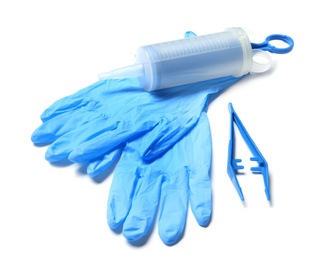 Photo of Medical gloves, disposable forceps and syringe on white background