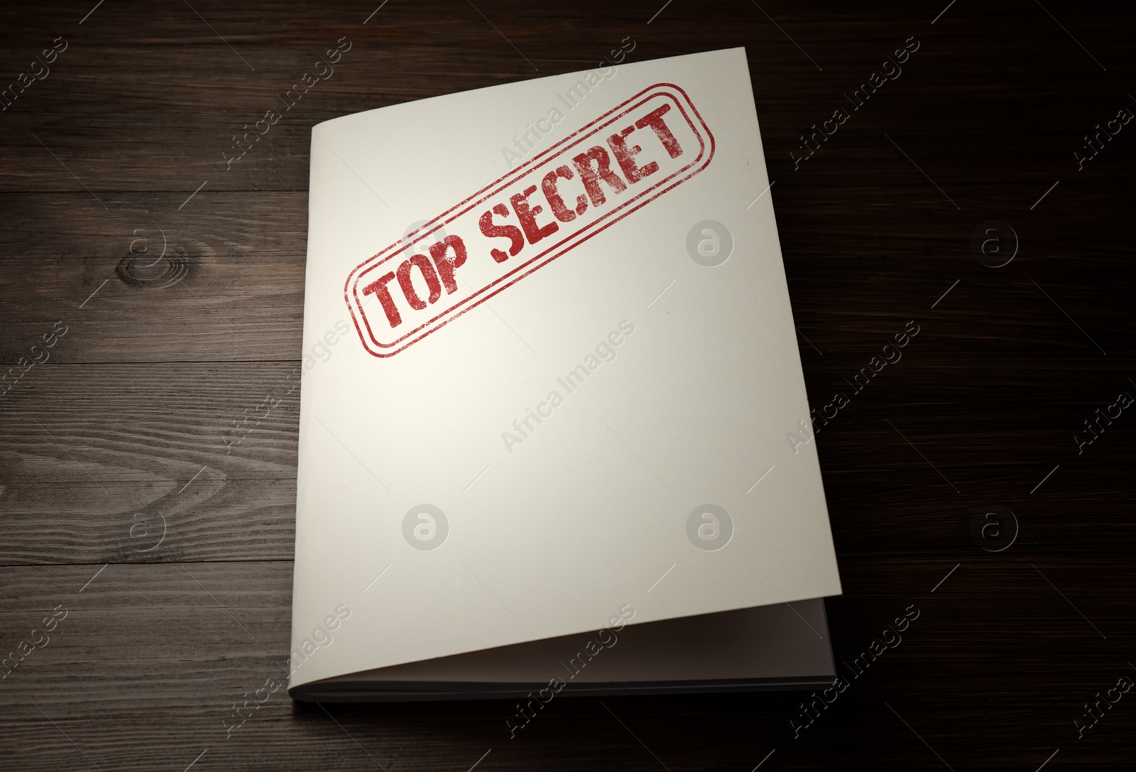 Image of White paper brochure with Top Secret stamp on wooden table