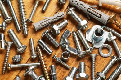 Photo of Many different fasteners on wooden table, above view