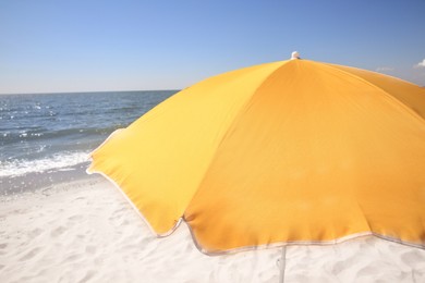 Photo of Orange beach umbrella near sea on sunny day