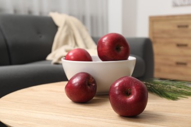 Red apples on wooden coffee table in room