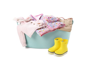 Photo of Laundry basket with baby clothes and rubber boots isolated on white