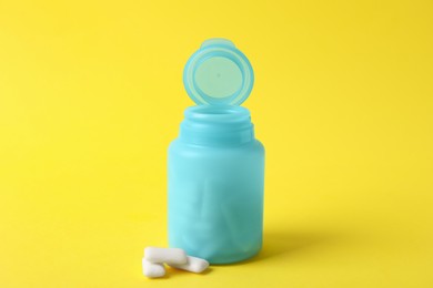 Photo of Jar with chewing gums on yellow background