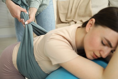 Doula working with pregnant woman at home. Preparation for child birth