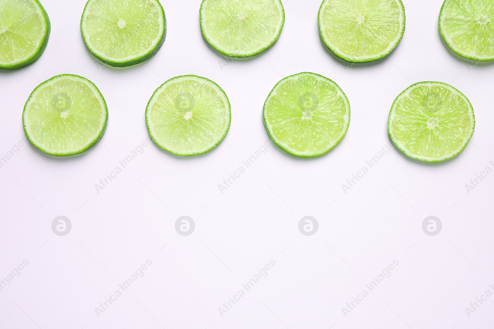 Photo of Juicy fresh lime slices on white background, top view