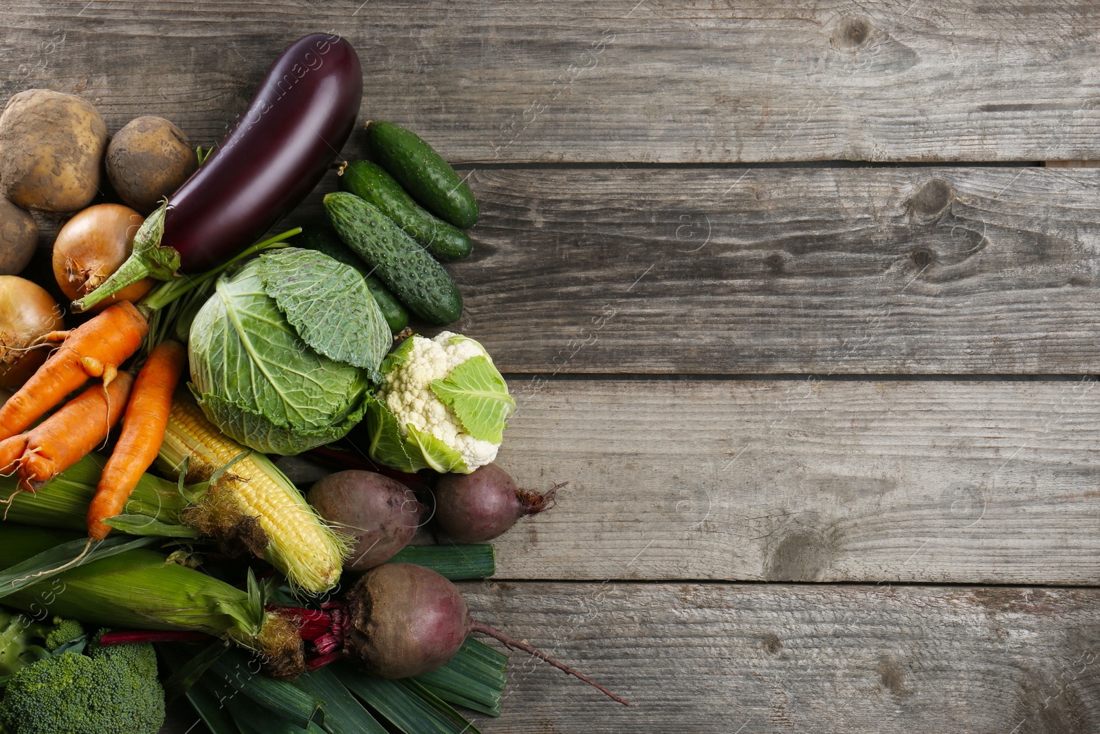 Photo of Different fresh ripe vegetables on wooden table, flat lay with space for text. Farmer produce