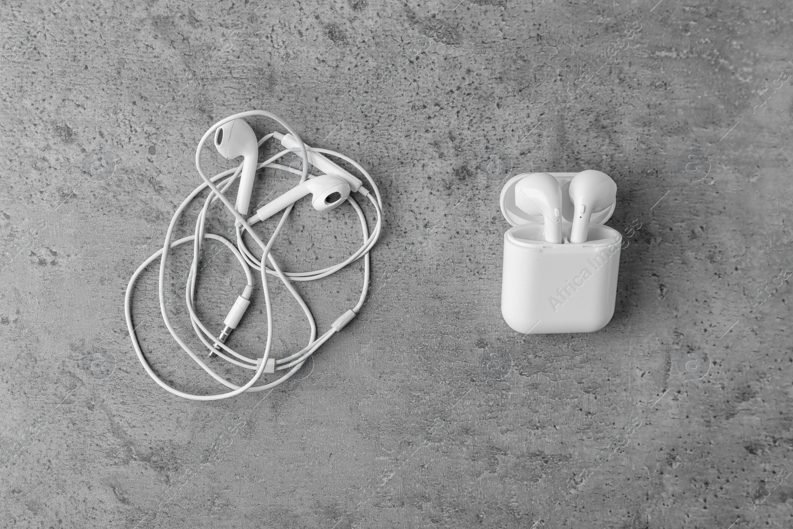 Photo of Flat lay composition with different earphones on grey stone background