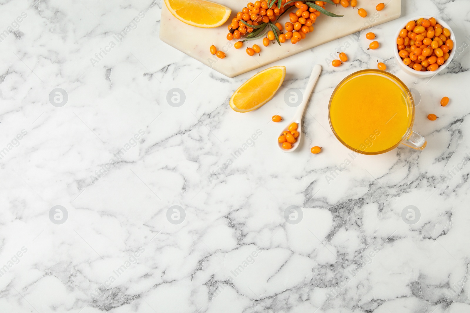 Photo of Fresh sea buckthorn tea on white marble table, flat lay. Space for text
