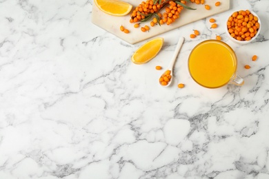 Photo of Fresh sea buckthorn tea on white marble table, flat lay. Space for text