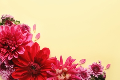 Photo of Flat lay composition with beautiful dahlia flowers and space for text on color background