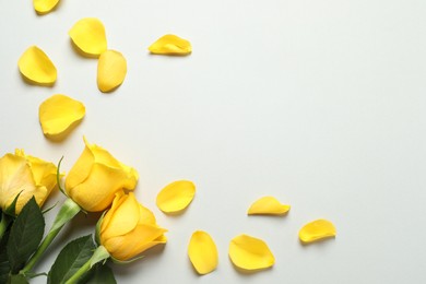 Photo of Beautiful yellow roses and petals on light grey background, flat lay. Space for text