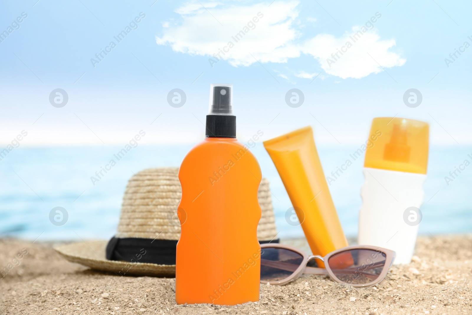 Photo of Composition with bottles of sun protection body cream on beach, space for design