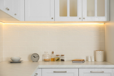 Different kitchen items and clock on countertop indoors