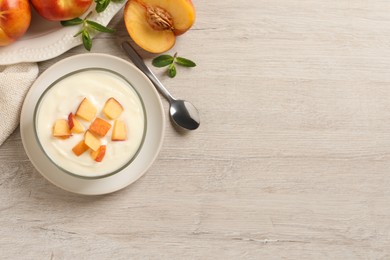 Photo of Delicious yogurt with fresh peach on light wooden table, flat lay. Space for text