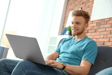 Young man using laptop in living room