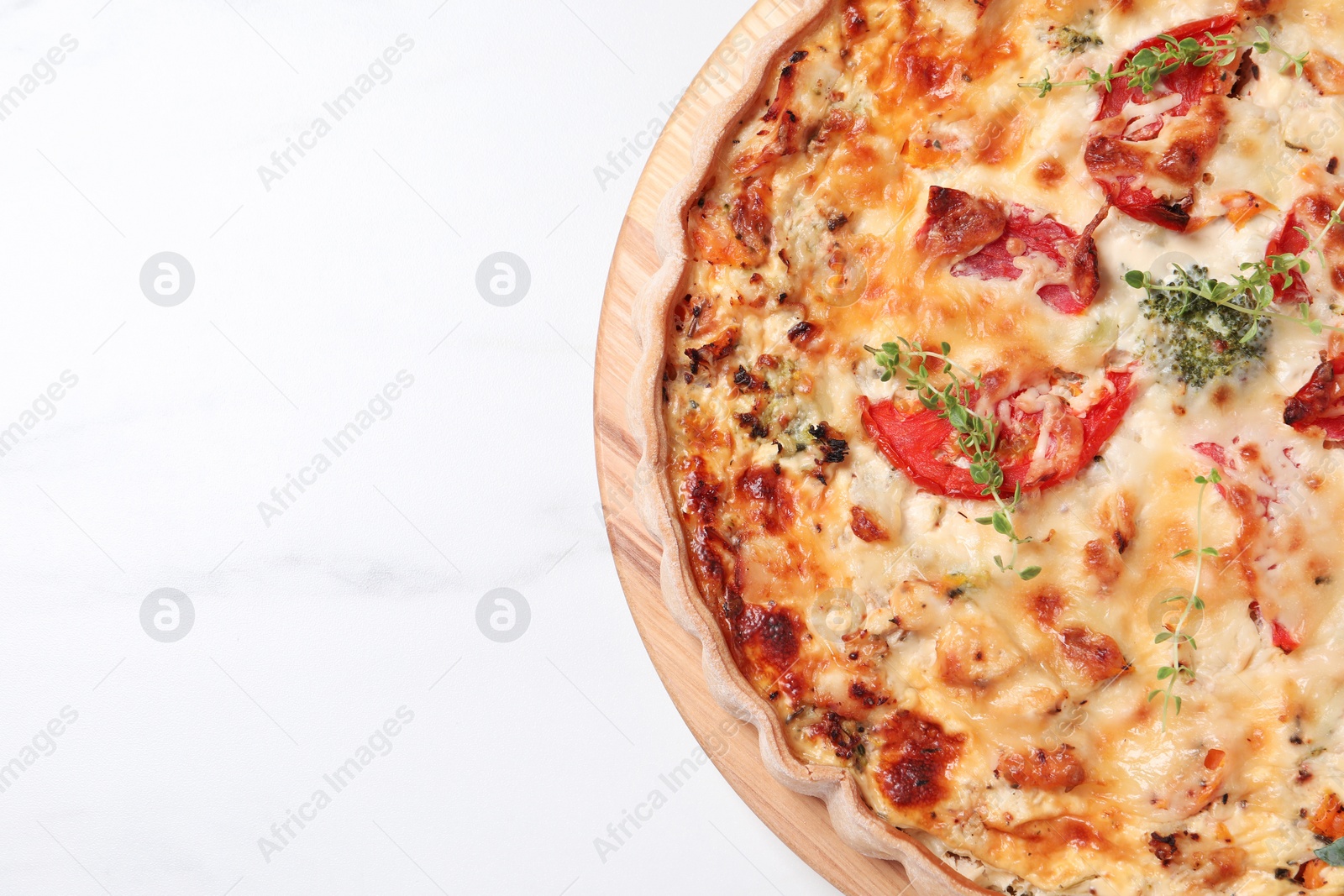 Photo of Tasty quiche with tomatoes, microgreens and cheese on white table, top view. Space for text