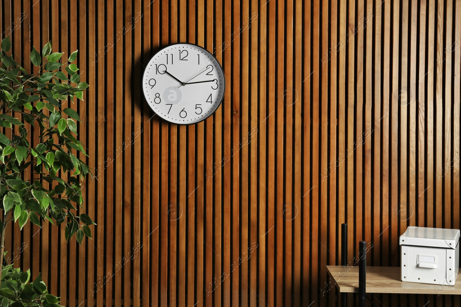 Photo of Room interior with clock and space for text on wooden wall. Time management