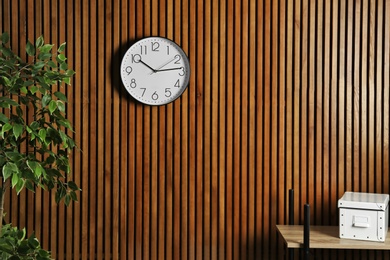 Room interior with clock and space for text on wooden wall. Time management
