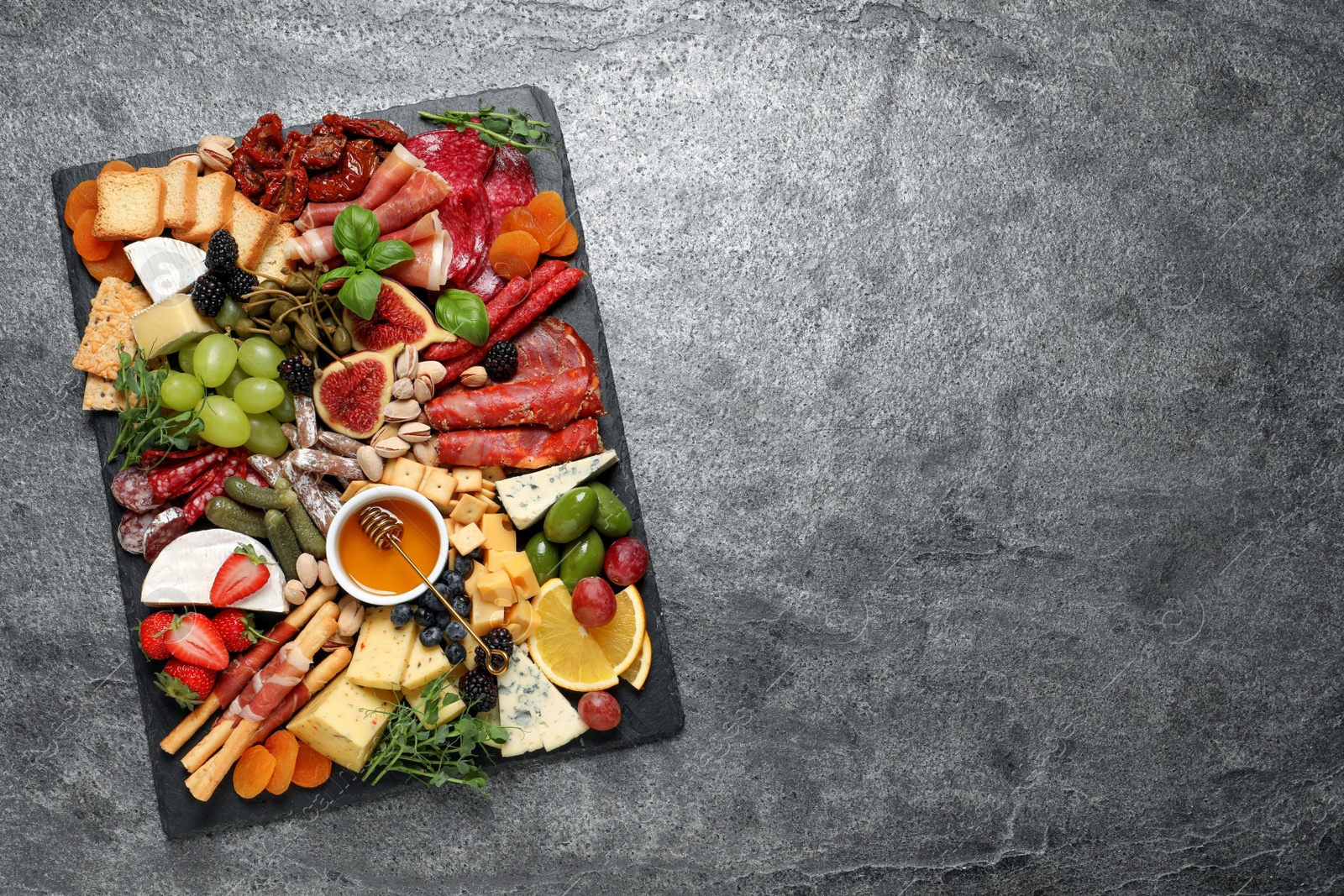 Photo of Set of different delicious appetizers served on grey table, top view. Space for text