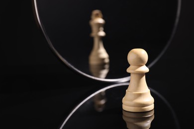 Photo of Pawn feeling itself like queen, chess piece in front of mirror. Self-appraisal, alter ego, true personality concepts