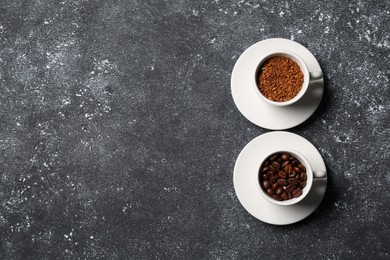 Photo of Cups with different types of coffee on dark grey table, flat lay. Space for text