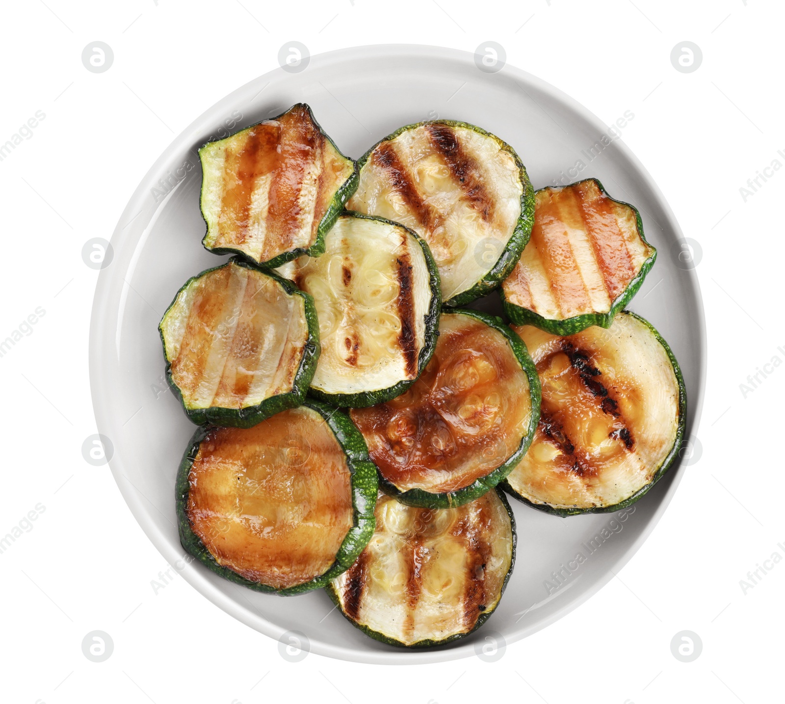 Photo of Plate of delicious grilled zucchini slices on white background, top view