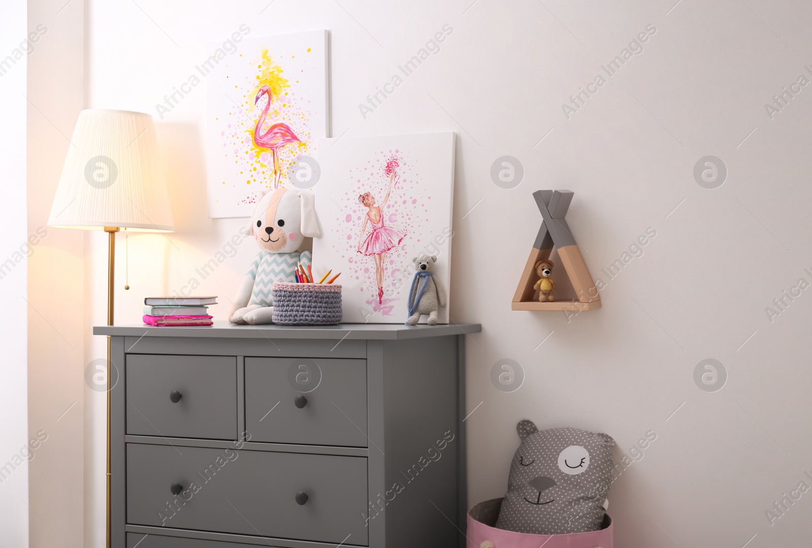 Photo of Chest of drawers and beautiful pictures in children's room. Interior design