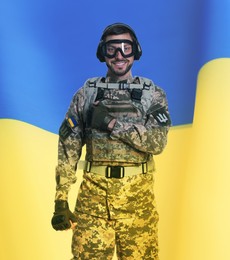 Image of Soldier in military uniform, tactical goggles and headphones and Ukrainian flag on background