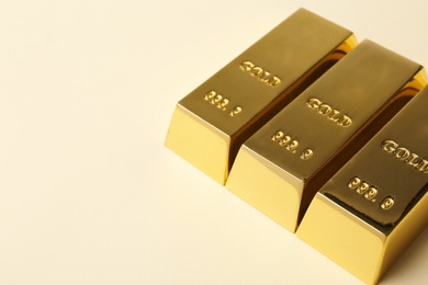 Photo of Shiny gold bars on light background. Space for text