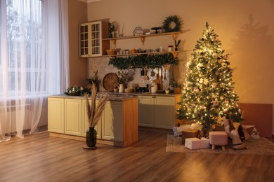 Stylish kitchen with festive decor and Christmas tree. Interior design