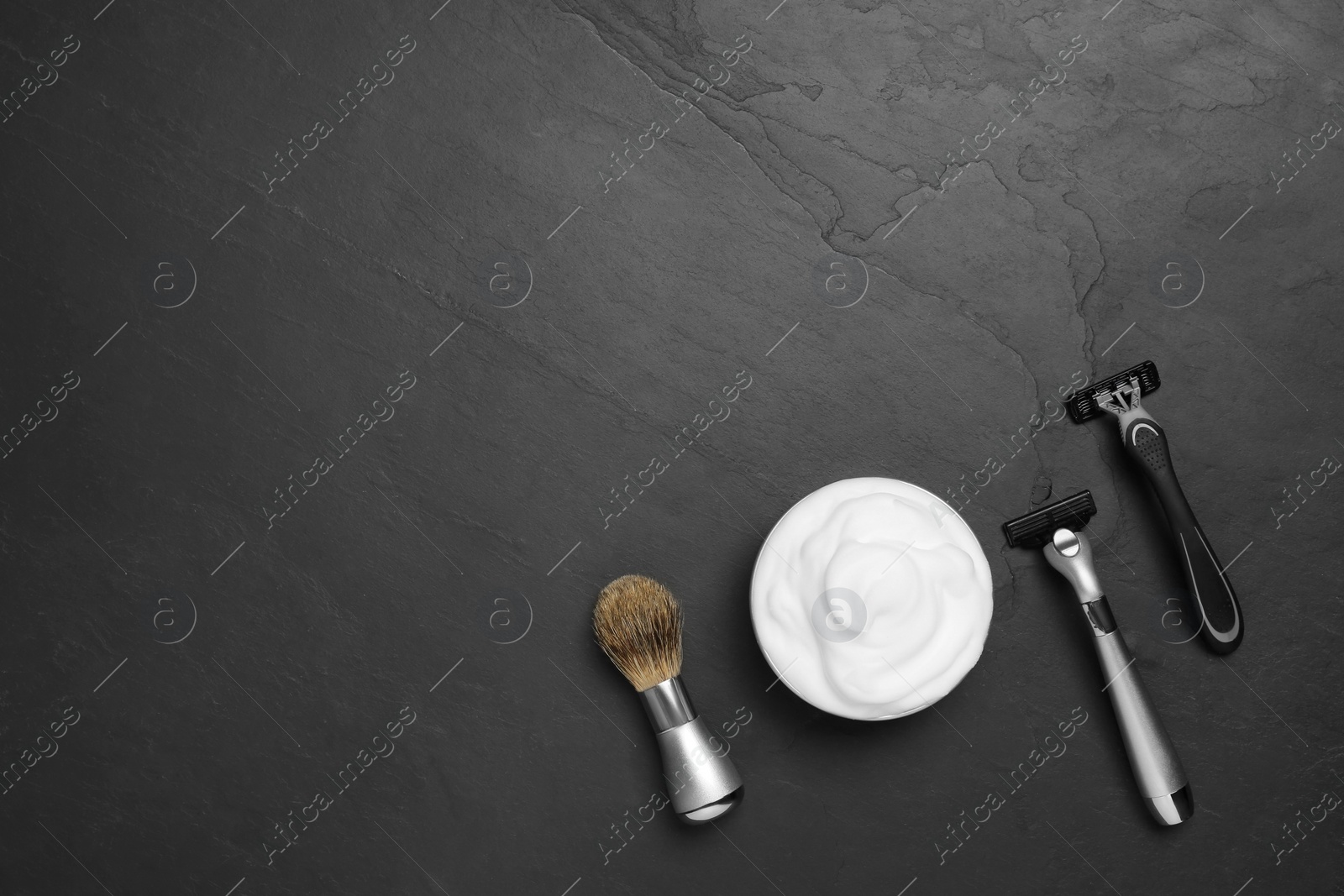 Photo of Set of men's shaving tools on black textured table, flat lay. Space for text