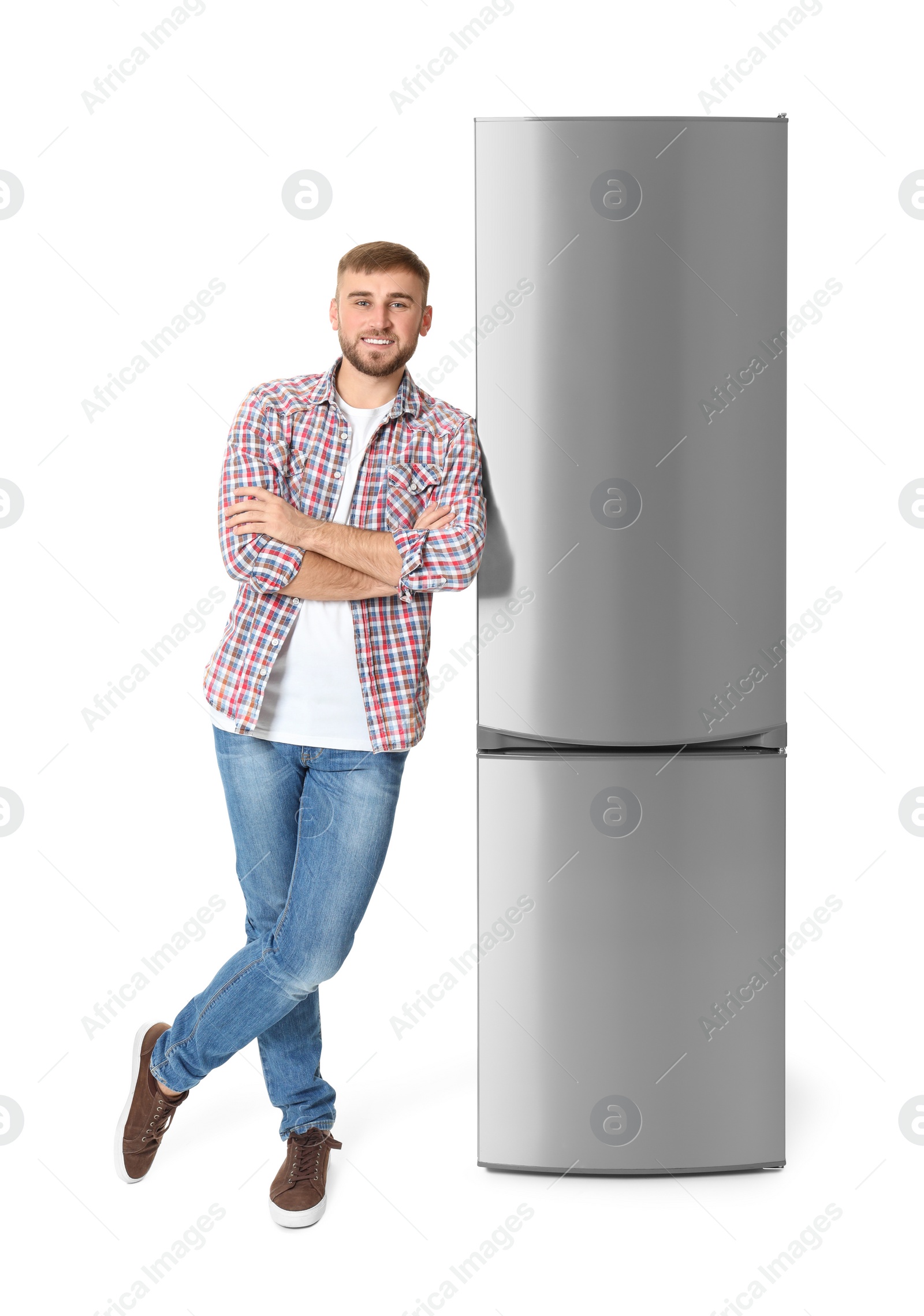 Photo of Young man near closed refrigerator on white background