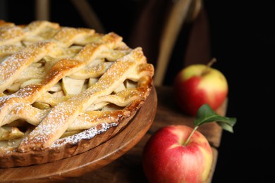 Delicious traditional apple pie on wooden stand, closeup
