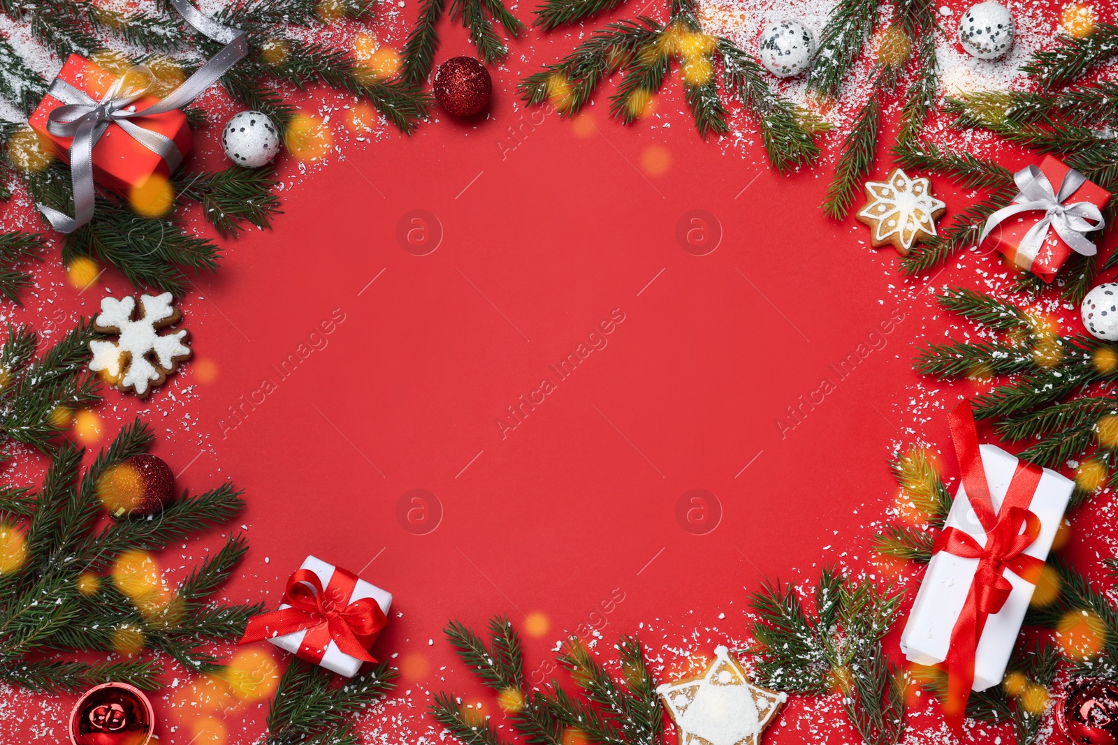 Photo of Christmas greeting card with space for text. Flat lay composition of fir tree branches and festive decor on red background