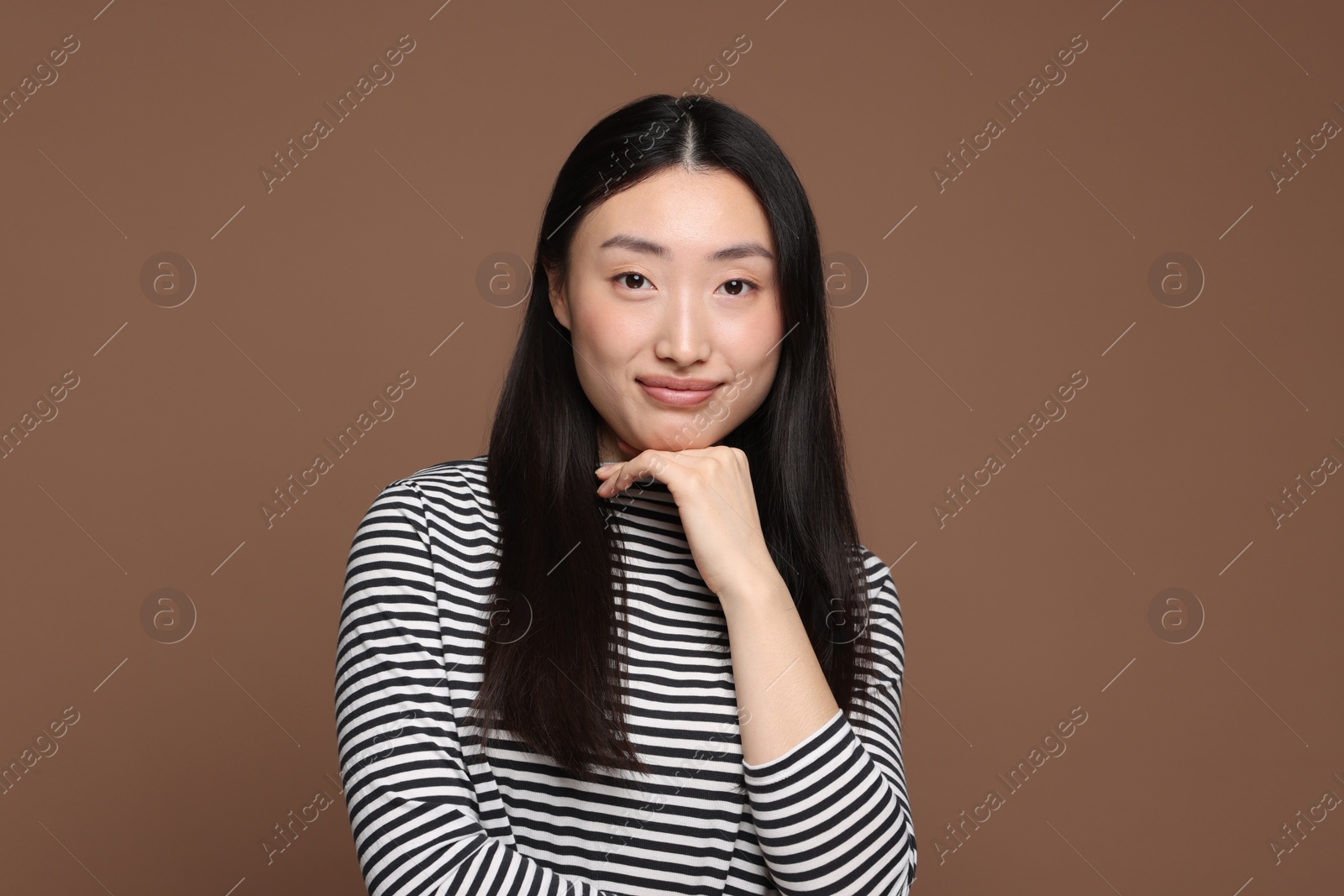 Photo of Portrait of beautiful woman on brown background