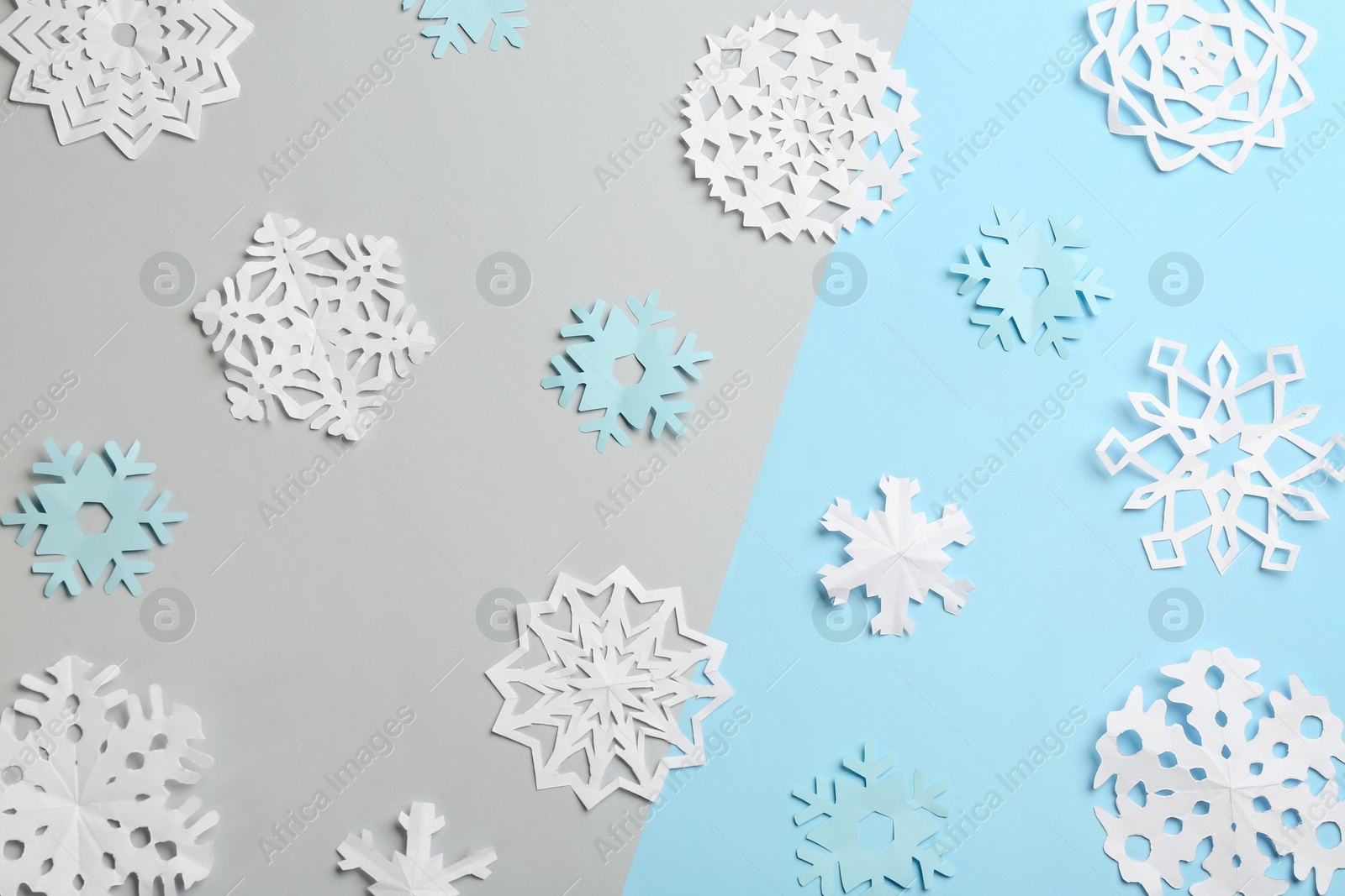 Photo of Many paper snowflakes on color background, flat lay