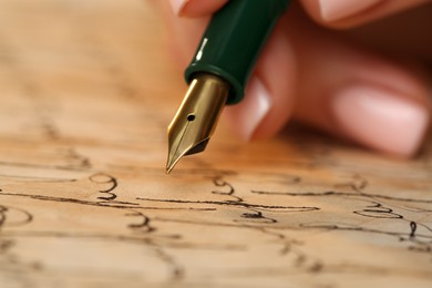 Photo of Woman writing letter with fountain pen, closeup