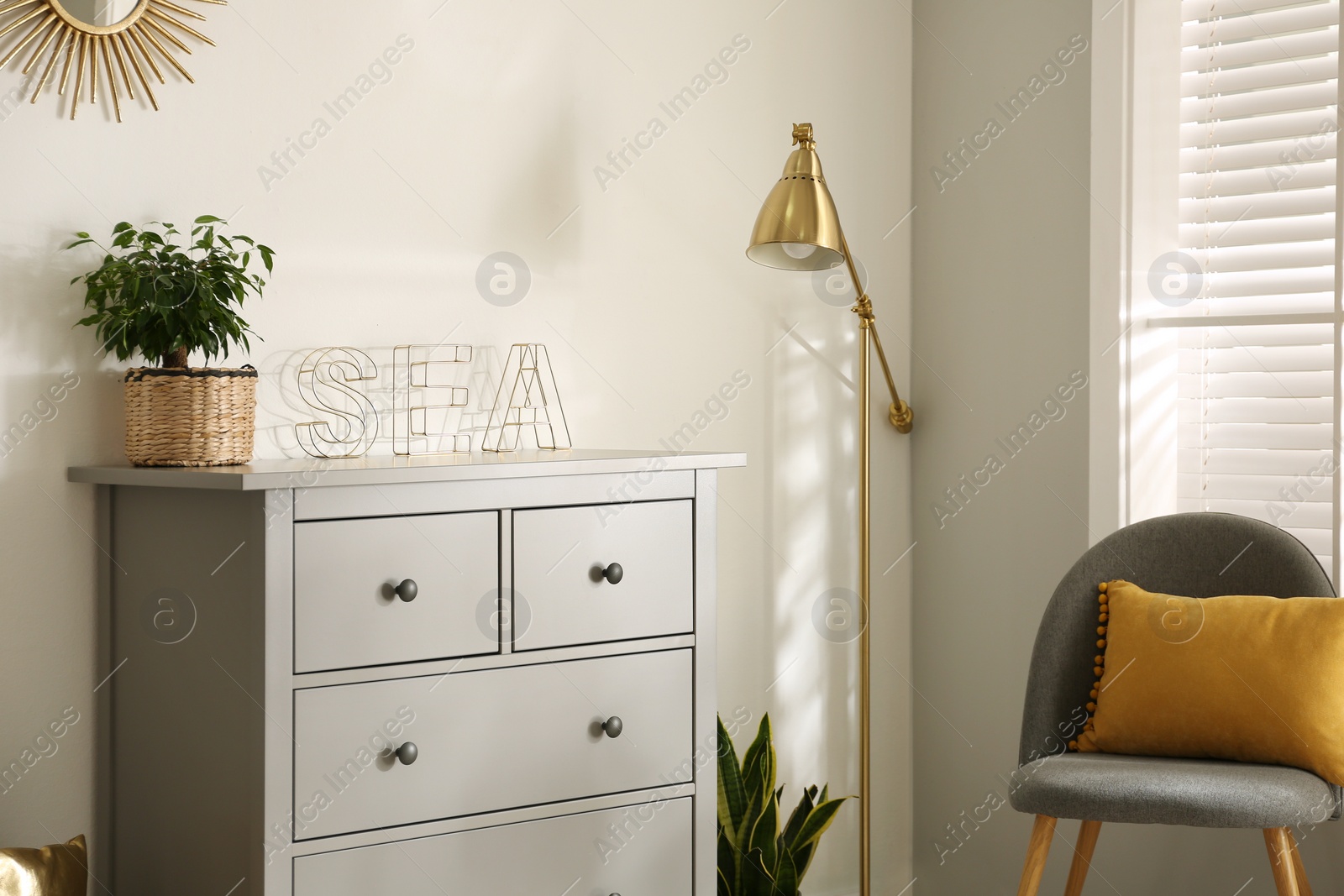 Photo of Grey chest of drawers in stylish room interior