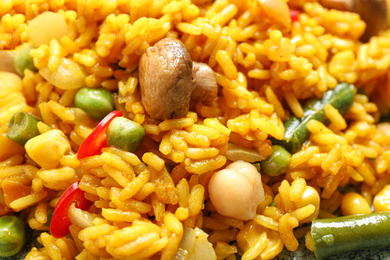 Photo of Delicious rice pilaf with vegetables as background, closeup