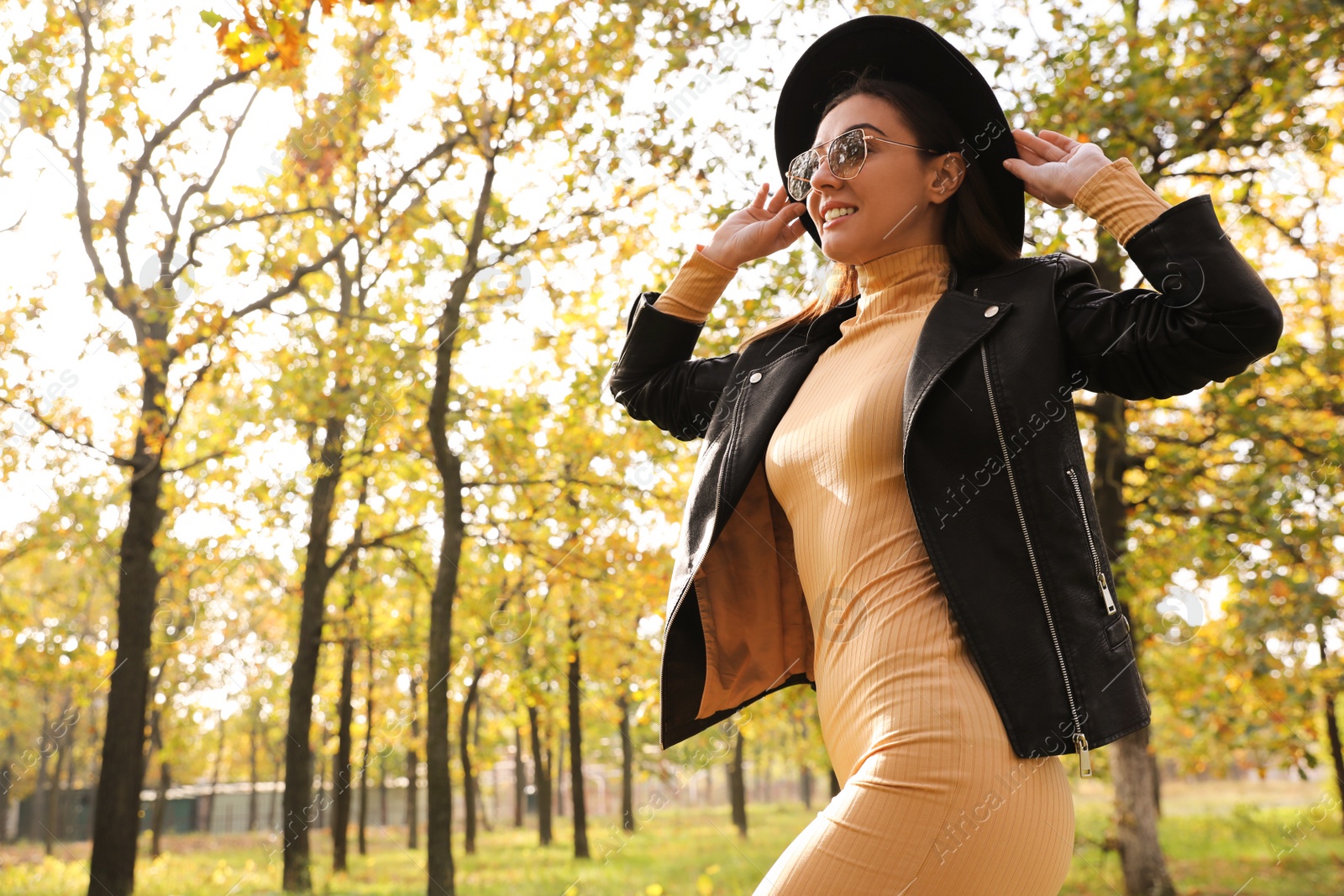 Photo of Beautiful happy woman walking in park on autumn day