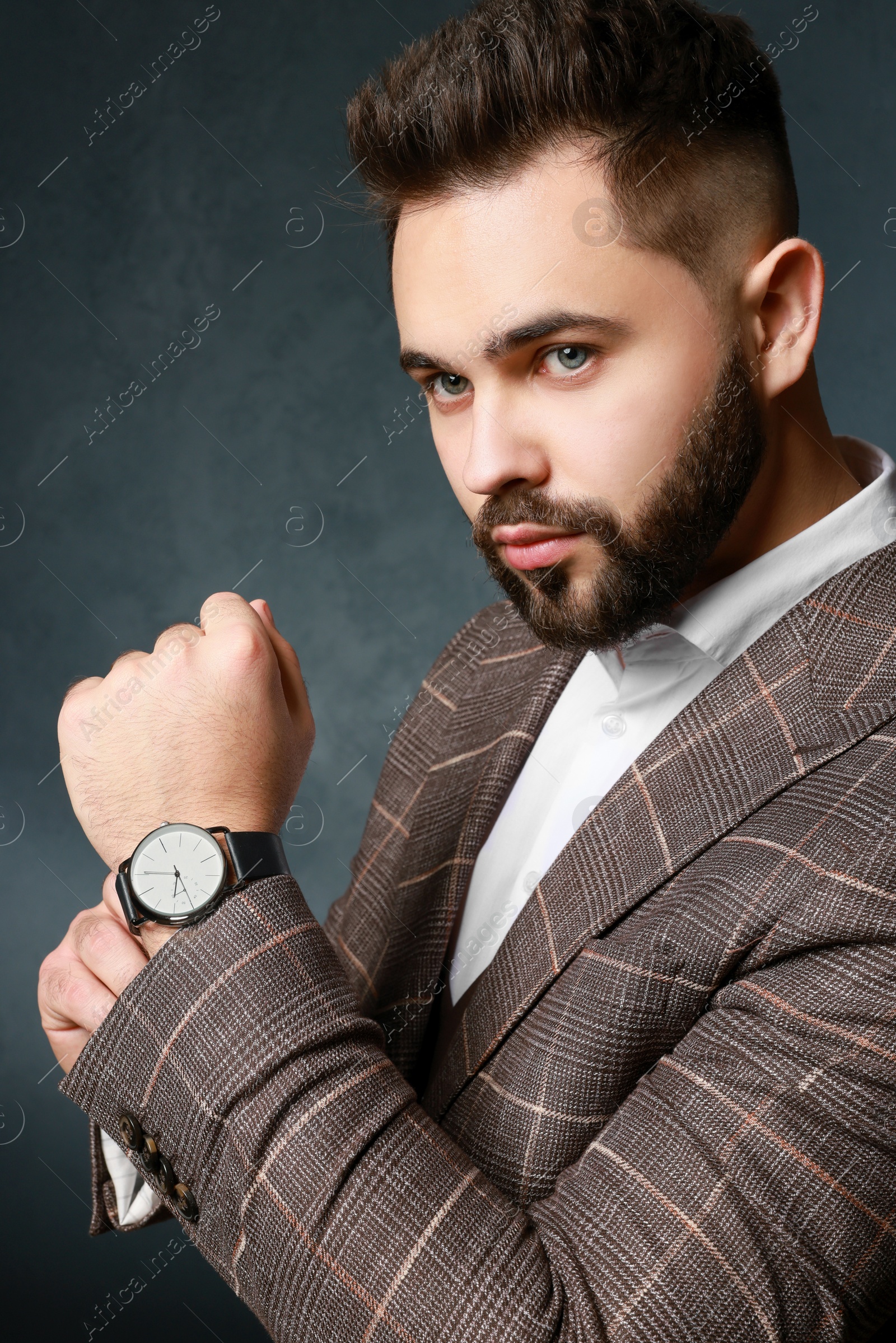 Photo of Handsome bearded man in stylish suit on dark background