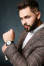 Handsome bearded man in stylish suit on dark background