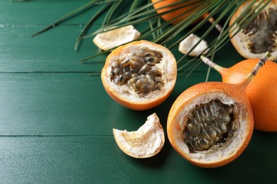 Photo of Delicious ripe granadillas on green wooden table