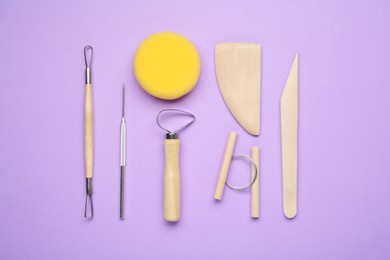 Set of clay modeling tools on violet background, flat lay