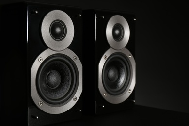 Modern powerful audio speakers on black background, closeup