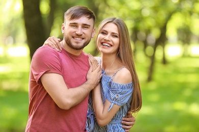 Happy young couple in green park on sunny spring day